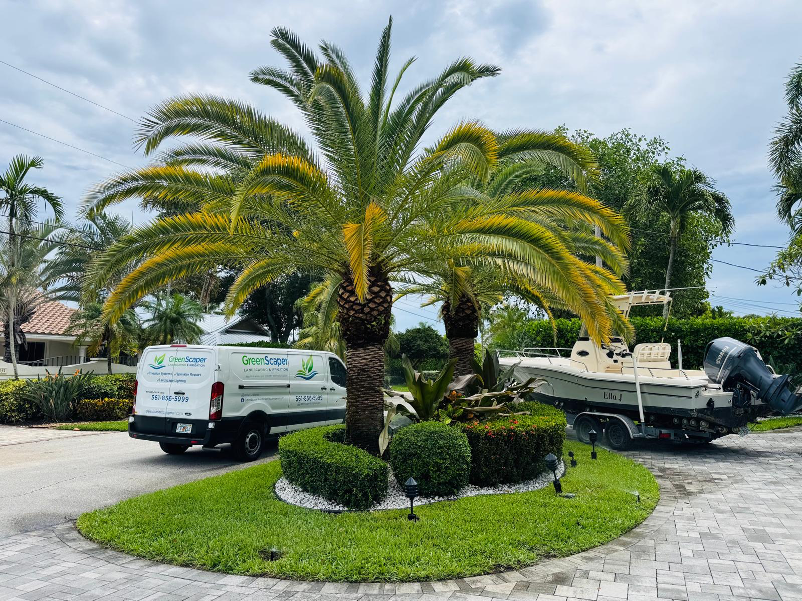 Greenscaper branded service van beside a landscaped property